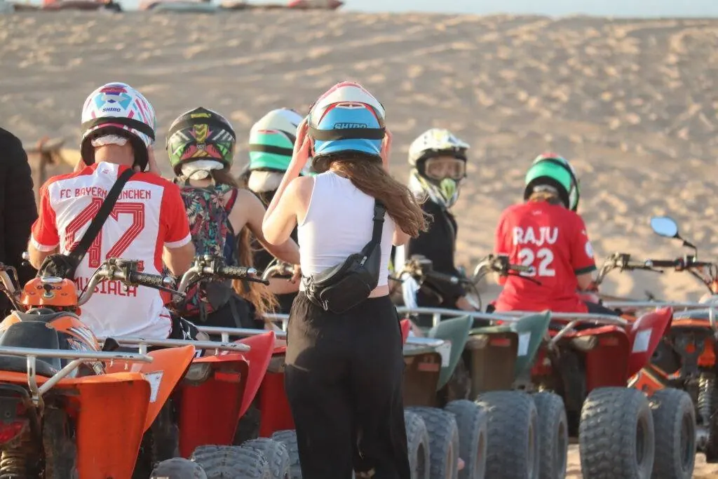 Surf and quad Tamraght: riders in helmets getting ready next to their quad bikes