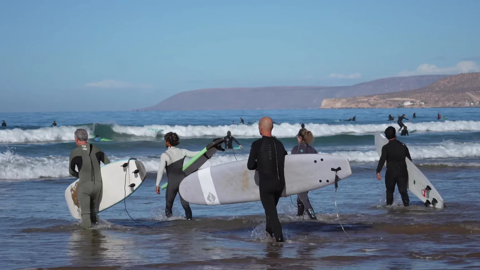 Surf camp guests walking into the ocean