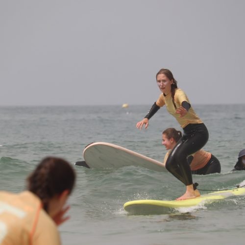 Intermediate surfer practicing turns with instructor